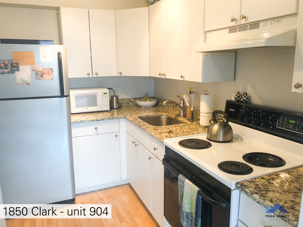 a kitchen with white cabinets and a stove and a refrigerator